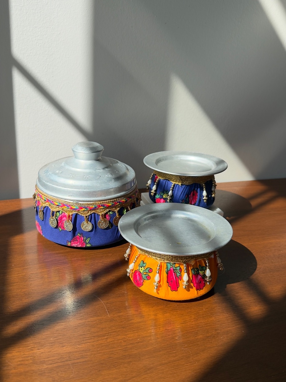 Set of three metal pots covered with traditional fabic